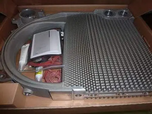 Remeha Wärmetauscher mit stabiler Aluminium-Oberfläche, verpackt in einem Karton, gemeinsam mit Zubehör und Anleitungen.